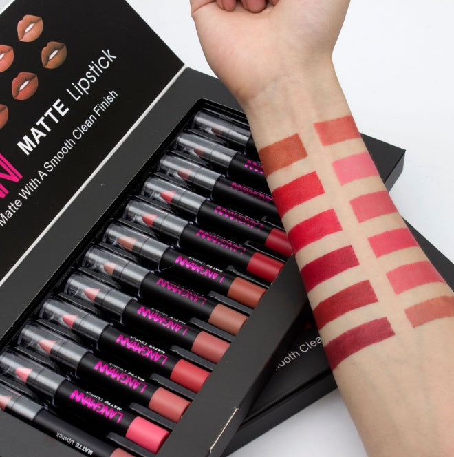 Set of matte lipsticks with a hand swatching various shades on a white background